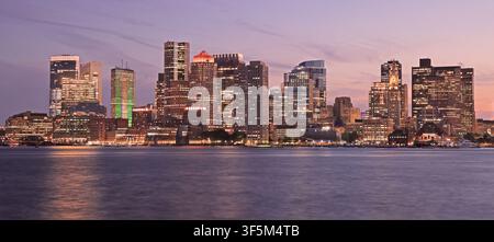 Skyline de Boston illuminée au crépuscule avec l'océan Atlantique au premier plan, États-Unis Banque D'Images