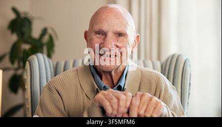 Portrait, sourire et homme âgé à la maison pour se détendre en retraite, attitude positive et optimisme. Heureux, personne âgée et reposant sur une chaise pour Banque D'Images