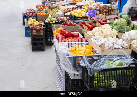 Fruits et légumes frais exposés dans des caisses à un marché en plein air à Boukhara, Ouzbékistan. Produits colorés comprenant des poivrons, de l'ail, des tomates et Banque D'Images