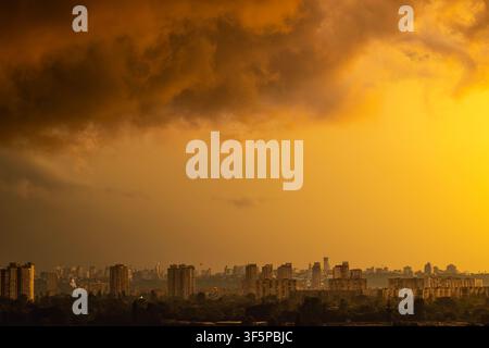 Kiev, vue panoramique de la ville ukrainienne surplombant la rivière Dnipro en direction du quartier de Pechersk avec des immeubles résidentiels imposants et une lumière dorée sous un ciel dramatique Banque D'Images