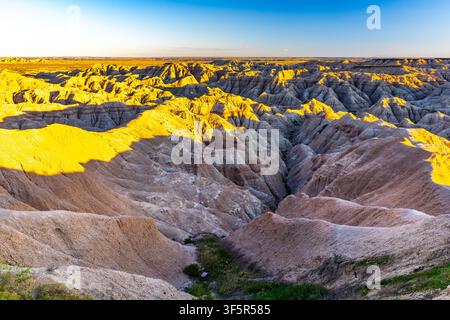 Vue panoramique des formations rocheuses érodées colorées et superposées et de la prairie dorée du parc national des Badlands, Dakota du Sud Banque D'Images