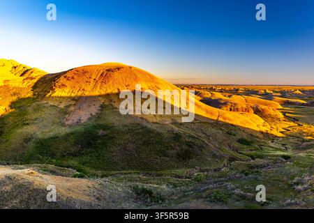 Vue panoramique des formations rocheuses érodées colorées et superposées et de la prairie dorée du parc national des Badlands, Dakota du Sud Banque D'Images