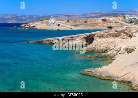 Bâtiments blanchis à la chaux sur une côte rocheuse avec une eau turquoise à Koufonisia, Grèce Banque D'Images
