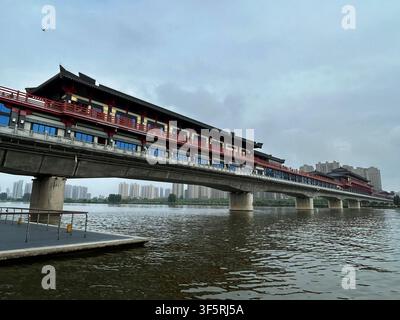 Vue du pont de ferry antique de Xianyang avec son architecture chinoise traditionnelle et ses rambardes rouges enjambant la rivière Wei à Xianyang, Shaanxi, Chine Banque D'Images