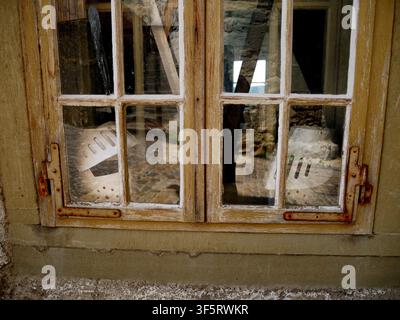 gros plan d'une vieille fenêtre en bois avec de la peinture écaillée et des charnières rouillées Banque D'Images