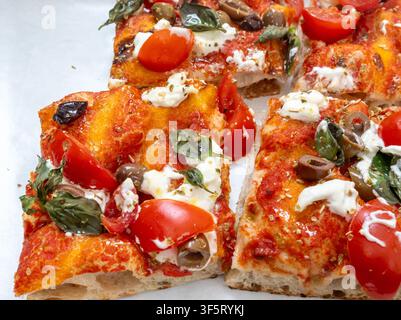 Pizza colorée sur plateau cuit au four ou pinza en boulangerie artisanale à Rome, nourriture de l'Italie, nourriture de rue pour le déjeuner, avec tomates, salami, basilic, mozzarella Banque D'Images