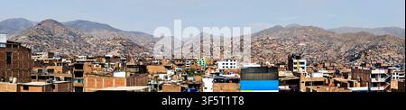Vue panoramique de l'étalement urbain coloré et des maisons construites sur les collines de San Juan de Lurigancho à Lima, au Pérou. Banque D'Images