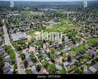 Vue aérienne capturant le quartier de Brevoort Park à Saskatoon. Un parc verdoyant s'étend parmi des rues résidentielles denses et des maisons. Les arbres encadrent les maisons avec Banque D'Images