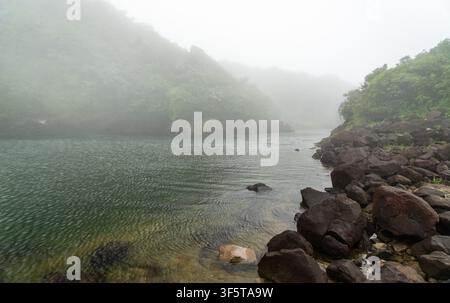 Vue panoramique du lac d'eau douce brumeux de Boeri entouré de collines vertes luxuriantes dans le parc national de Morne Trois Pitons, Dominique. Banque D'Images