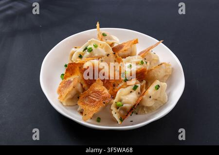 Dumplings croustillants guotie saupoudrés d'oignon vert haché Banque D'Images