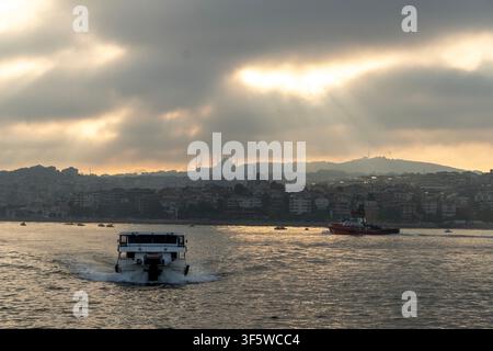 Istanbul, Turquie. 4 août 2026. Un ferry traverse l'eau tandis qu'une ligne d'horizon urbaine est visible en arrière-plan à Istanbul, Turquie. (Crédit image : © Moe Zoyari/ZUMA Press Wire) UTILISATION ÉDITORIALE UNIQUEMENT ! Non destiné à un USAGE COMMERCIAL ! Banque D'Images