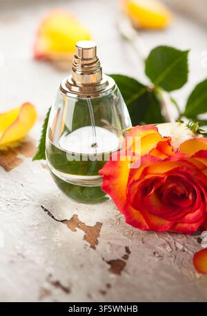 bouteille de parfum et rose rouge et jaune sur le vieux bureau Banque D'Images