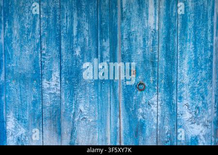 Vieille porte vieillie par le temps en bois naturel peint en bleu intense Banque D'Images