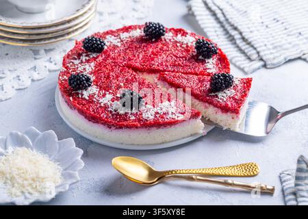 Gâteau au yaourt au coco sans cuisson rafraîchissant avec une garniture vive aux baies et des mûres Banque D'Images