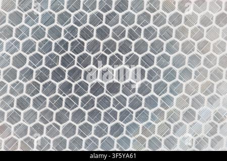 Un motif mosaïque de carreaux hexagonaux avec des carreaux en céramique gris texturés disposés en nid d'abeille, évoquant un rythme géométrique apaisant Banque D'Images