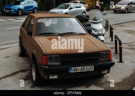Herceg Novi, Monténégro - 24 juin 2026. Une Opel break vintage garée le long d'une rue urbaine avec un trafic moderne passant à proximité. Le véhicule usé Banque D'Images