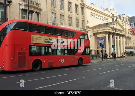 Un bus rouge vif à deux étages de Londres passe devant le Theatre Royal Haymarket historique dans le centre de Londres, Royaume-Uni. Le bus présente Banque D'Images