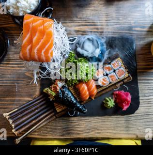 Assortiment de sushi artistiquement présenté avec un effet de glace sèche fumée, du saumon frais et une présentation élégante de repas japonais. Photo de haute qualité Banque D'Images