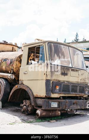 Ancien camion-citerne à carburant rouillé abandonné sans roue avant debout à l'extérieur dans une décharge. Véhicule lourd vintage soviétique, camion-citerne endommagé, rouille, décadence et concept de ferraille métallique. Banque D'Images