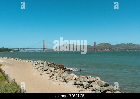 Le Golden Gate Bridge enjambe la baie de San Francisco, vu d'une plage rocheuse avec les Marin Headlands qui s'élèvent en arrière-plan Banque D'Images