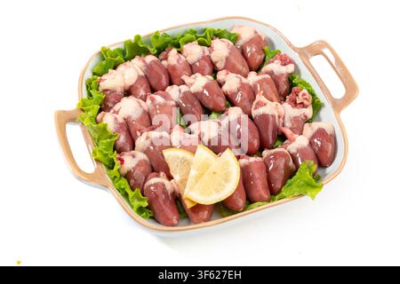 Cœurs de poulet crus dans un bol avec citron Banque D'Images