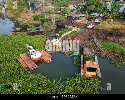Vue aérienne d'excaveurs lourds retirant les sédiments et les jacinthes d'eau du Rawa Pening pour préserver la profondeur du lac à Tuntang, Java central, Indonésie Banque D'Images