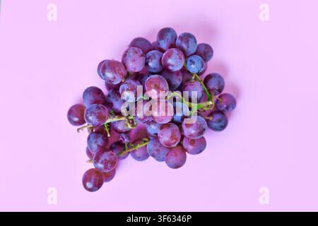 Vue de dessus d'une grappe de raisin rouge sur fond rose Banque D'Images