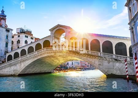 Pont du Rialto historique illuminé par la lumière du soleil au-dessus du Grand Canal à Venise, Italie. L'un des sites architecturaux les plus photographiés d'Europe. Banque D'Images