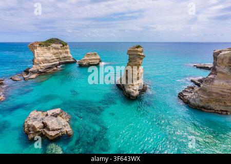 Falaises de calcaire s'élevant des eaux turques claires comme du cristal de la mer Adriatique aux Faraglioni di Sant'Andrea, l'un des paysages côtiers les plus spectaculaires du Salento. Melendugno, province de Lecce, Pouilles, Italie Banque D'Images