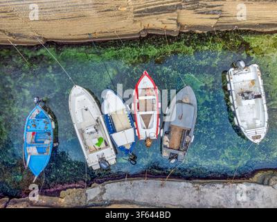Vue aérienne des bateaux de pêche amarrés dans les eaux cristallines de Cala Porticciolo, Santa Cesarea Terme, province de Lecce, Pouilles, Italie Banque D'Images