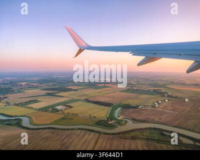 Vue aérienne au lever du soleil depuis une fenêtre d'avion sur la campagne vénitienne près de Venise, Vénétie, Italie Banque D'Images
