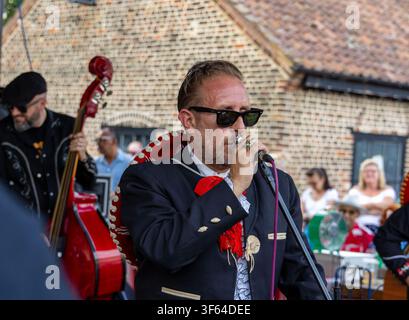 Carlos et les Banditos en concert à Rockin’ at the Mills à Merton Abbey Mills, avec le chanteur vêtu d'une tenue de style mariachi et une contrebasse sur une scène en plein air Banque D'Images