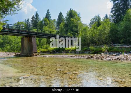 Un pont ferroviaire historique traverse l'Ammer, rivière peu profonde et cristalline, dans la pittoresque région de Scheibum dans le défilé de l'Ammer, entourée d'une végétation luxuriante Banque D'Images