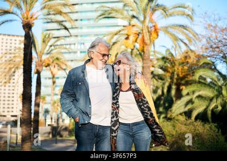 Heureux couple senior marchant dans un parc ensoleillé Banque D'Images
