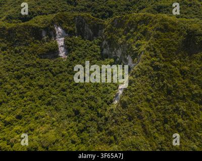 Vue aérienne de la Laguna de Cuicocha présentant des pentes de cratère volcanique luxuriantes et vertes, une végétation forestière dense et des falaises rocheuses à Cotacachi, Imbabura, Équateur Banque D'Images