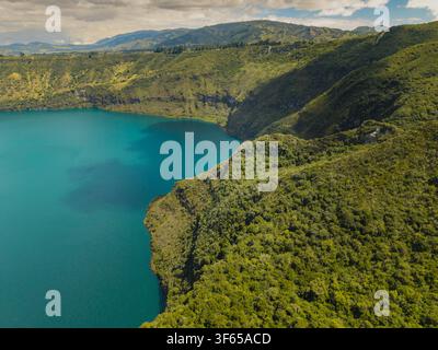 Vue aérienne de la Laguna de Cuicocha avec ses eaux turquoise éclatantes entourées de pentes de cratère volcanique vertes et luxuriantes à Cotacachi, Imbabura, Équateur. Banque D'Images