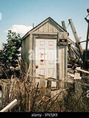 Un hangar patiné avec un panneau « No Parking » et une végétation envahissante se dresse au milieu de la décrépitude à Provincetown, Massachusetts Banque D'Images