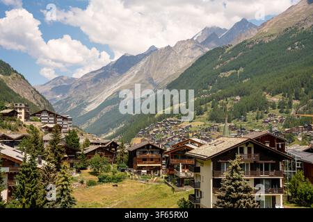 Zermatt, Suisse - 24 juin 2026 : Vue panoramique paysage de chalets traditionnels en bois nichés dans la vallée alpine verdoyante de Zermatt, Suisse Banque D'Images