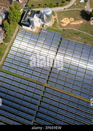 Vue aérienne d'une centrale solaire thermique avec des rangées de panneaux solaires, des réservoirs de stockage et la verdure environnante en Allemagne. Banque D'Images