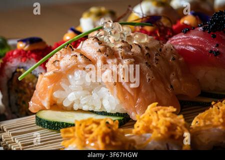 Vue rapprochée de sushi variés avec saumon, riz et garnitures. Banque D'Images