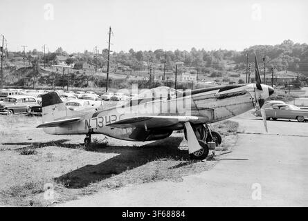 Avion de combat nord-américain P-51D-25-NT Mustang N7343C garé parmi des voitures américaines classiques de l'époque sur un terrain d'Intercoastal Aircraft Inc, probablement dans les années 1960, quelque part aux États-Unis. (date exacte inconnue). Cité comme étant en service actif avec l'United States Army Air Force avec le numéro de série 44-84857 en 1944/45, puis en 1951 à la Garde nationale aérienne 170th FBS. Vendu sur le marché civil en 1963 et immatriculé sous le nom N7343C. Plus tard, en 1969, vendu à l'armée de l'air du Salvador mais perdu lors du vol de livraison. Certaines pièces auraient été récupérées par la suite pour être utilisées dans une reconstruction aux États-Unis Banque D'Images