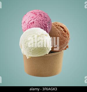 Boules de glace colorées dans un gobelet en papier sur fond bleu Banque D'Images