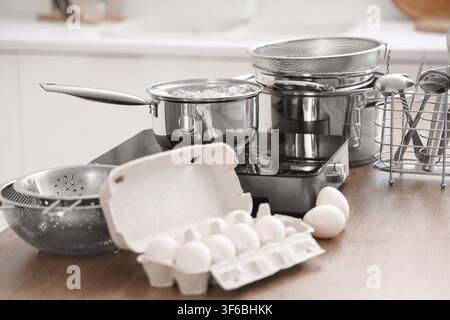 Casserole avec de l'eau bouillante sur mini-cuisinière et des oeufs dans la cuisine Banque D'Images