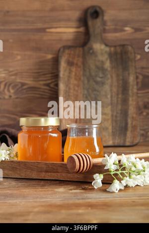 Potons de miel avec des fleurs d'acacia sur fond en bois Banque D'Images