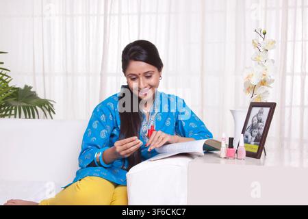 Les jeunes femmes l'application de vernis à ongles Banque D'Images