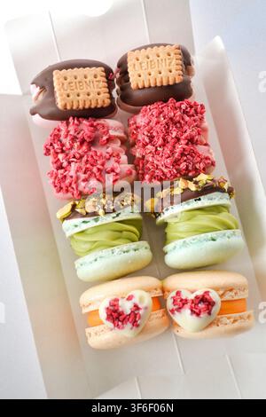 Ensemble de fatcarons coréens gastronomiques avec biscuits, pistache et décor en forme de cœur dans une longue boîte blanche Banque D'Images