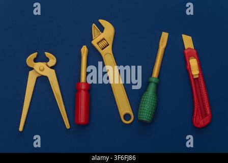 Outils de travail en jouet sur un fond bleu classique. Couleur 2020 Banque D'Images