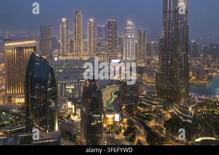 Vue aérienne de la skyline illuminée de Dubaï mettant en vedette le Burj Khalifa et les gratte-ciel modernes au crépuscule à Dubaï, Dubaï, Émirats arabes unis. Banque D'Images