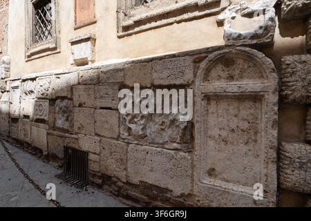 Anciens reliefs étrusques et romains encastrés dans le mur du Palazzo Bucelli, Montepulciano, Toscane, Italie Banque D'Images