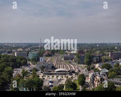 Vue aérienne des voies ferrées de la gare Baltique et du paysage urbain environnant avec des arbres verts et des bâtiments modernes à Tallinn, comté de Harju, Estonie Banque D'Images